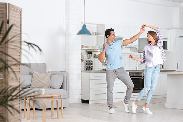 Beautiful-young-couple-dancing-in-kitchen-at-home